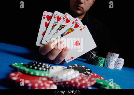 Junger Mann mit Royal Flush Poker Tisch Stockfoto