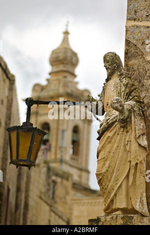 Statue mit Laterne mit Kirchturm im Hintergrund Stockfoto