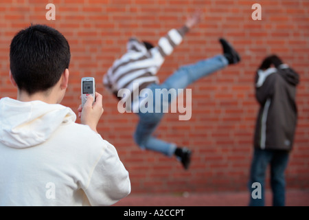 zwei Jungen kämpfen und gefilmt von einem anderen Stockfoto