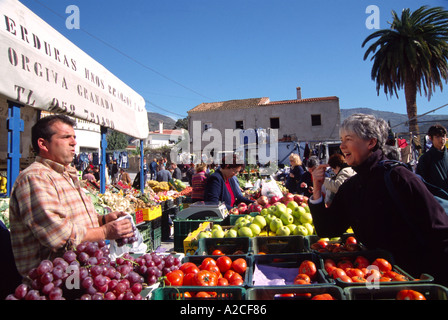 Gemüse im Markt Orgiva Alpujarras Südspanien 56 Jahre alte Engländerin bespricht Geschmack mit spanischen Händler Stockfoto