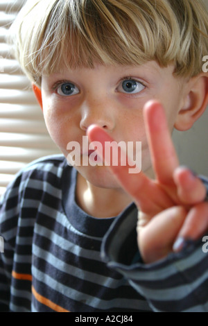 Kind hält sich drei Finger zum Geburtstag Stockfoto