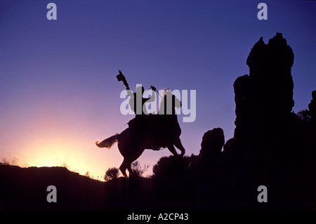 "Cowboy auf Pferd, winken Hut, Silhouette gegen den Himmel wie"Lone Ranger", Mojave, Kalifornien, USA" Stockfoto