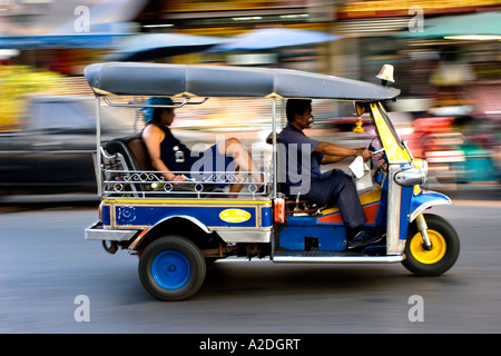 Ein Tuk Tuk beschleunigt vorbei mit einem Touristen an Bord. Stockfoto