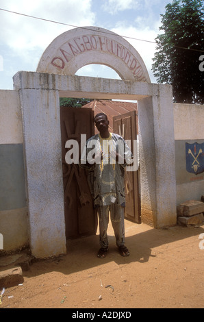 Der Reiseleiter steht vor dem Daagbou Hounoun Zentrum für Voodoo, Ouidah, Benin. Stockfoto