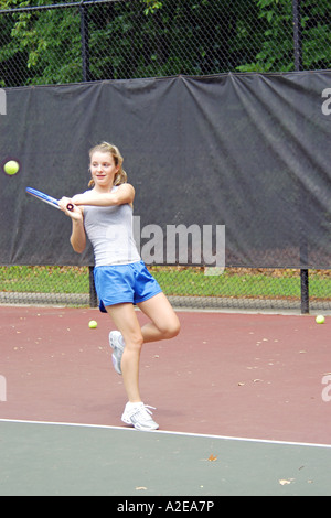 Weibliche Teenager Gymnasiast übt ihr Tennis-Fähigkeiten in einem öffentlichen Programm in Michigan Stockfoto