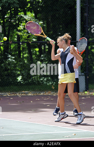 Teenager weibliche High-School-Schüler lernt, Tennis zu spielen, in einem öffentlichen Programm in Michigan Stockfoto