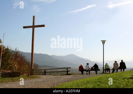 Besucher Touristen und Pilger genießen die Aussicht vom Kalvarienberg in Richtung der Alpen Bad Tölz Bayern Deutschland Stockfoto