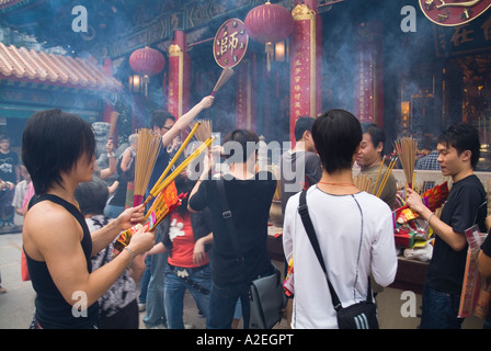 dh Wong Tai Sin Tempel WONG TAI SIN HONGKONG Junge Gläubige mit Joss Sticks Tempel bauen Weihrauch Jugendliche Asiaten china Kultur Stockfoto