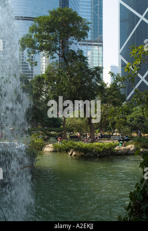 dh Hong Kong Park CENTRAL HONG KONG Lotus Pool Wasserfall Baum Menschen entspannen Multi-geschossiges Gebäude Stockfoto