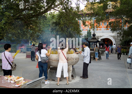 dh Po Lin Kloster LANTAU HONG KONG Worshippers an Räucherstäbchen Urn Eingang zum Tempel Stockfoto