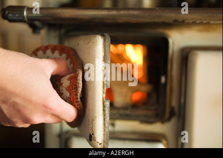 Frau Eröffnung Holzofen, close-up Stockfoto