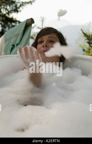 Junge Frau im weht Blubber Badewanne liegend Stockfoto