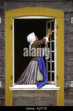 Kanada, Nova Scotia. Louisburg Festung. Frau, die Reinigung der Fenster in traditioneller Tracht. Stockfoto