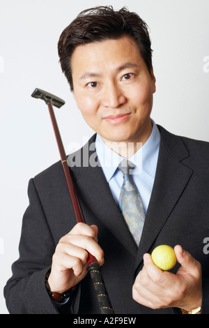 Nahaufnahme eines Geschäftsmannes hält ein Golfclub und ein Golfball Stockfoto