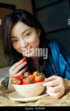 Porträt einer jungen Frau eine Erdbeere essen Stockfoto