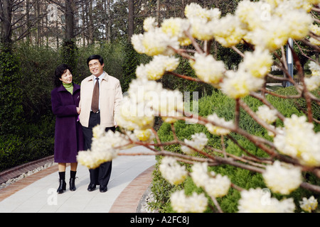 Reifen Sie paar gehen gemeinsam in einem Garten lächelnd Stockfoto