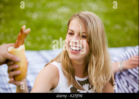 Junge Frau nehmen gegrillte Würstchen, portrait Stockfoto