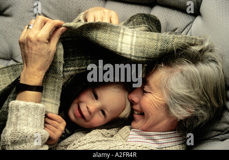Großmutter und Enkel spielen Peek-a-boo Unterdecke Stockfoto