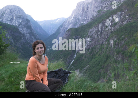 Frau genießt Aussicht auf tiefes Tal zwischen Sogne Fjord und Hardanger Fjord in der Nähe von Voss, Norwegen (MR) Stockfoto