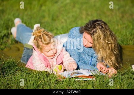 Mutter mit Tochter in der Wiese liegen Stockfoto