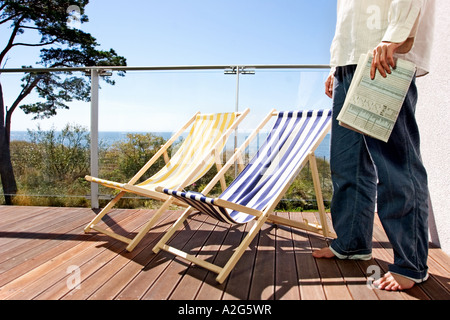 1221148 Terrasse im freien Tag Sommer Meer Wasser Baum Bäume fragment Mann weißes Hemd Hose Jean Jeans barfuß Fuß Füße Stockfoto