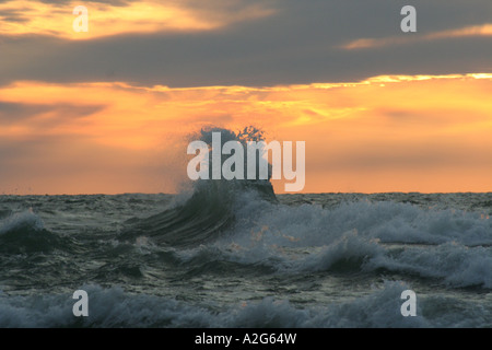 Wellen gegen die untergehende Sonne Stockfoto