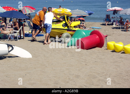 Männer schieben Jet Ski auf einem Wagen über den Strand, La Cala de Mijas, Mijas Costa, Costa Del Sol, Spanien, Europa, Stockfoto