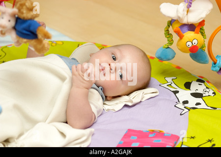 Baby Boy auf Spielmatte liegend Stockfoto