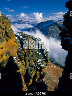 ROCKY MOUNTAIN NATIONAL PARK, COLORADO. USA. Frischer Schnee auf den Klippen über dem Wald Canyon & Wolken. Longs Peak in Ferne. Stockfoto
