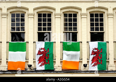 Waliser und irische Flaggen hängen von Windows vor einem Pub in Cardiff City centre Wales UK Stockfoto