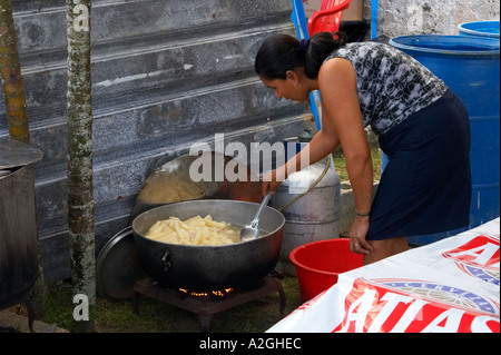 Eine Frau bereitet einige Yuca für den Verkauf. Shes mit einem kleinen gasbetriebenen Herd Stockfoto