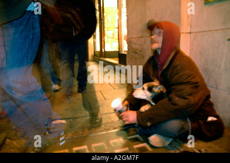 Obdachloser mit seinem Hund auf Londons Straßen betteln. Stockfoto