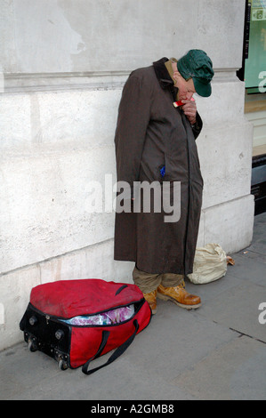 Obdachlosen Mann spielen Mundharmonika Betteln auf der Londoner Regent Street. Stockfoto