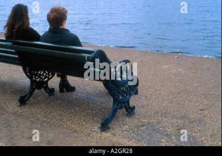 Paar auf Bank sitzen und Blick auf das Wasser der Serpentine Hyde Park London England Stockfoto