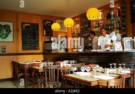 Im Cafe de l'Esperance in Bouliac. Typisch französischen traditionellen Café Restaurant. Holz-Tische Stühle, Weingläser und Servietten auf den Tischen. An der Wand eine Tafel Tafel Kreide schwarz board mit Menü, zwei Kellner an der Bar für das Mittagessen vorbereiten. Bordeaux Gironde Aquitaine Frankreich Europa Stockfoto