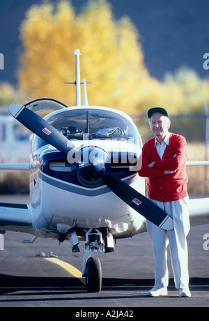 Ein lächelnder senior Mann steht selbstbewusst neben seiner einmotorigen Flugzeug Stockfoto