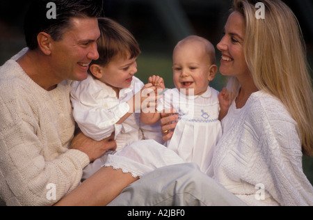 Vater und Mutter sitzen im Freien mit ihren kleinen Sohn und Baby in ihre Runden Stockfoto