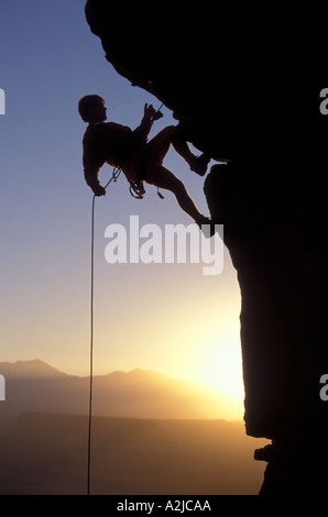 Silhouette von einem Bergsteiger einer Klippe abseilen Stockfoto