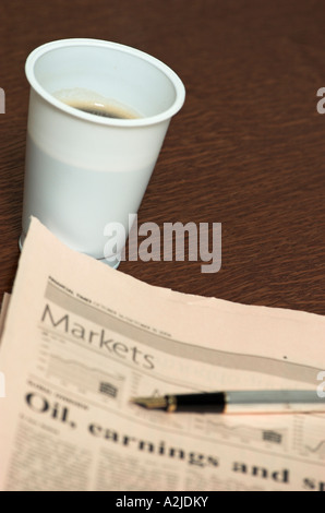 Tasse schwarzen Kaffee und Füllfederhalter auf Finanzzeitung Stockfoto