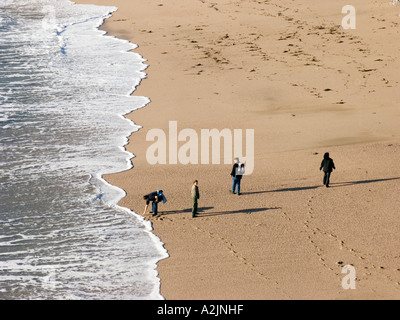 Wanderer an einem Wintertag an den Rand des Wassers auf Mattiscombe Beach, South Devon. Großbritannien Stockfoto
