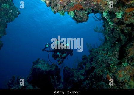 Eine Fotografin sieht in einer Höhle auf einem Riff in Little Cayman Stockfoto