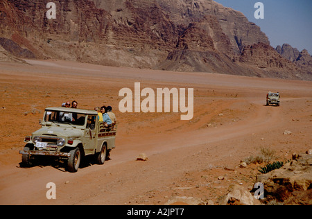 Asien, Jeeps, Wadi Rum, Jordanien führen die Besucher durch den roten Sand Wüste Wadi Rum vorbei an riesigen Felsformationen Stockfoto