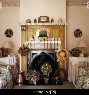 Edwardian Kiefer Kamin mit getrockneten Blumenarrangements in achtziger Jahre Wohnzimmer mit Tüchern auf kleine Runde Tische Stockfoto