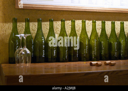 Flaschen, aufgereiht in der Probierstube mit Kreide schreiben und zwei Upside-Down-Wein Gläser und Korken, Maison Louis Jadot, Beaune Côte d ' Cote d oder Bourgogne Burgund Burgund Frankreich Französisch Europa Europäische gekennzeichnet Stockfoto