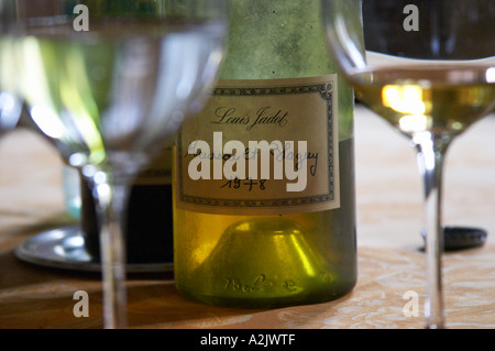 Ein halb leeren staubige alte Flasche mit einem handgeschriebenen Etikett Louis Jadot Meursault Blagny 1978 Weißburgunder und zwei Gläser Stockfoto