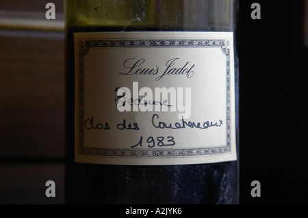 Eine halb leere staubige alte Flasche mit einer handgeschriebenen Etikett Louis Jadot Beaune Clos des Couchereaux 1983 Burgund rot Wein Seite beleuchtete Seite Licht, Closeup, Maison Louis Jadot, Beaune Côte d ' Cote d oder Bourgogne Burgund Burgund Frankreich Französisch Europa Europäische Stockfoto