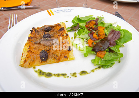 Eine Tarte fine d Oignon - denken Sie Zwiebelkuchen mit Salat mit Oliven und Sardellen. Das Restaurant Le Verger de Papes in Châteauneuf-du-Pape Vaucluse, Provence, Frankreich, Europa Stockfoto