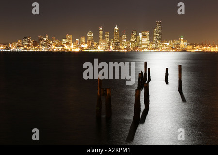 Seattle Stadt Skyline bei Nacht mit Pfählen und Licht des Vollmondes spiegelt sich in Elliot Bay Seattle Washington USA Stockfoto