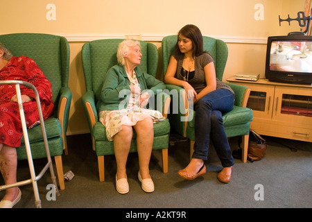 junge Mädchen/Teenager /care Arbeitskraft Besuch sehr alte Dame / Großmutter im Pflegeheim Stockfoto