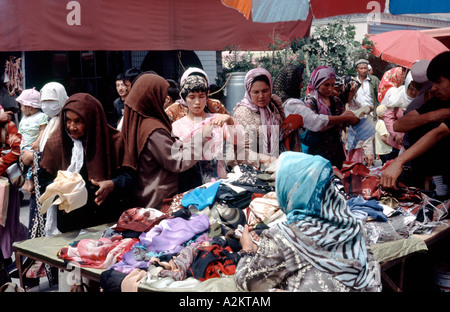 2. Juli 2006 - Markt uigurischen Frauen Auswahl Stoffe in Kashgar Sonntag in der westlichen chinesischen Provinz Xinjiang. Stockfoto